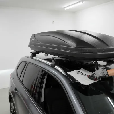 Inno Phantom Cargo Roof Box being installed on a vehicle rooftop.